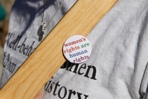 Person wearing pin that says \'Women\'s rights are human rights\'